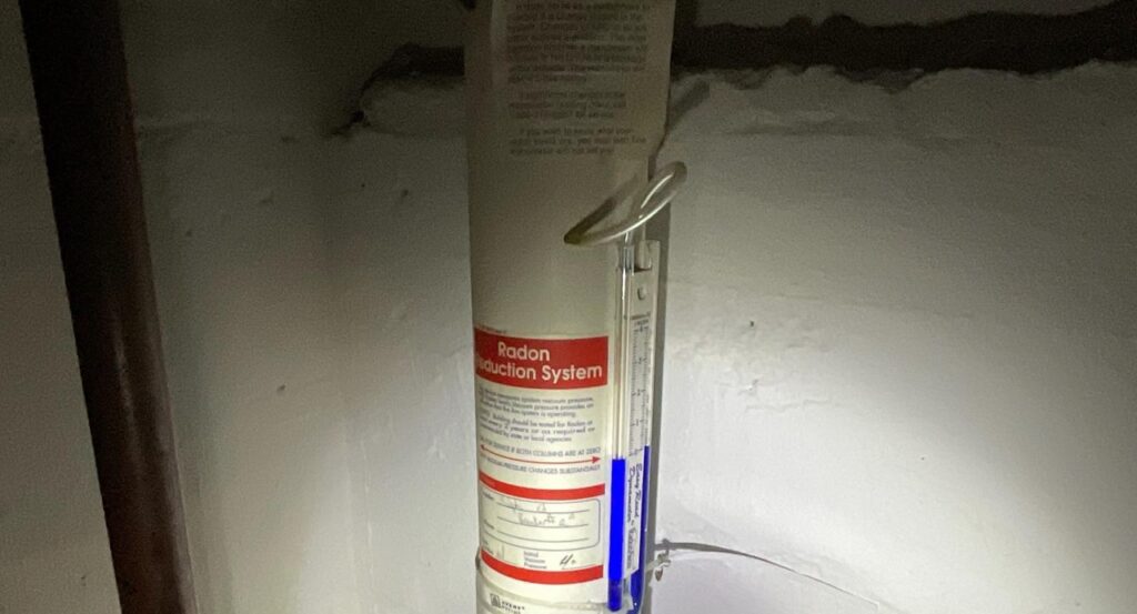 U-tube manometer on a radon reduction system pipe in a New Jersey basement