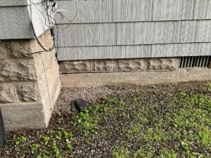 Foundation wall and crawlspace vent at the base of a home exterior during an inspection