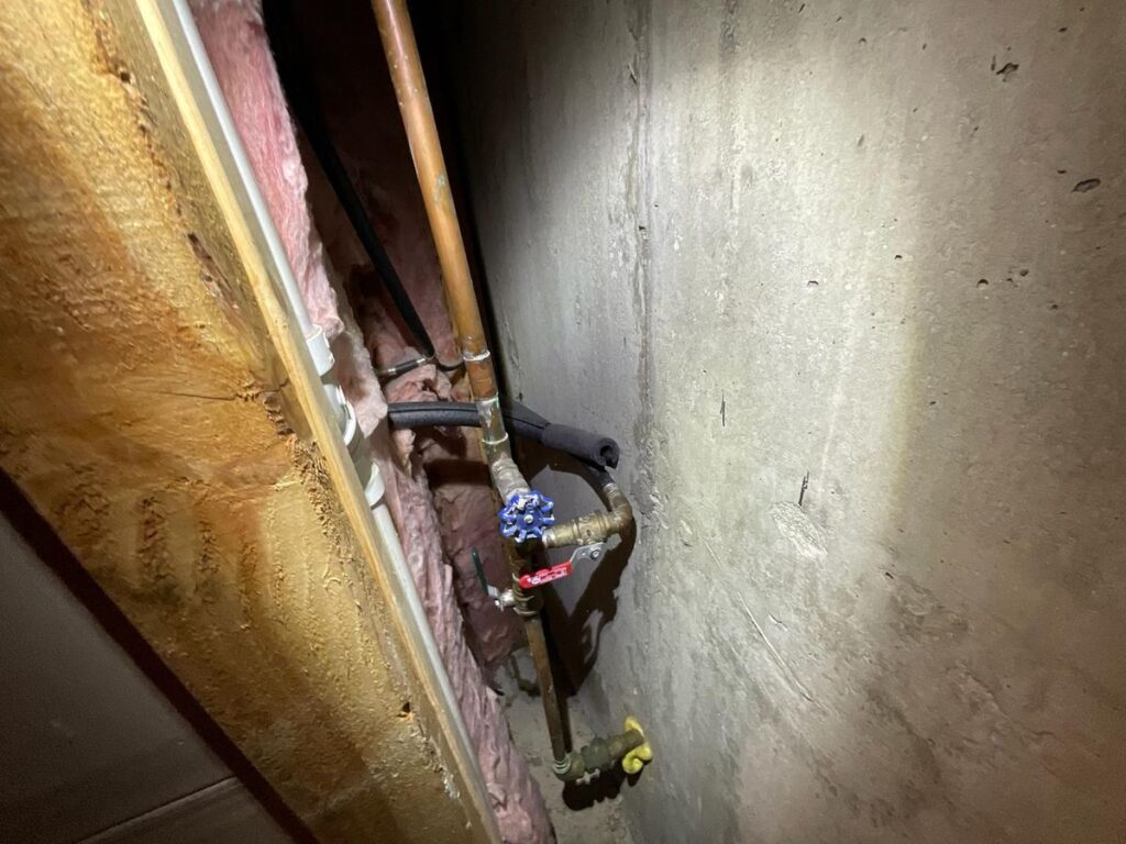 Main water shutoff valve hidden behind a basement wall, found during a Monmouth County home inspection
