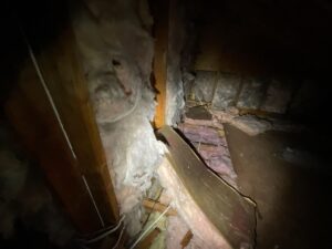 Fallen and drooping fiberglass insulation between attic joists, photographed during a Monmouth County home inspection