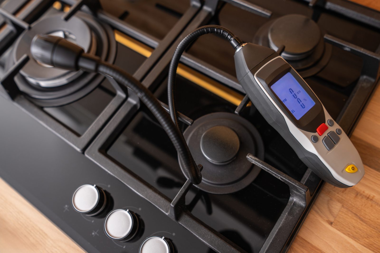 Gas stove being checked with a handheld leak detector