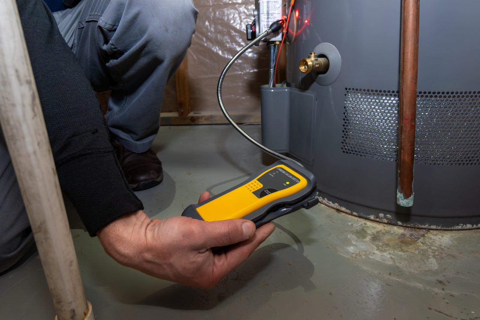 Home inspector examining fuel connections in a residential basement